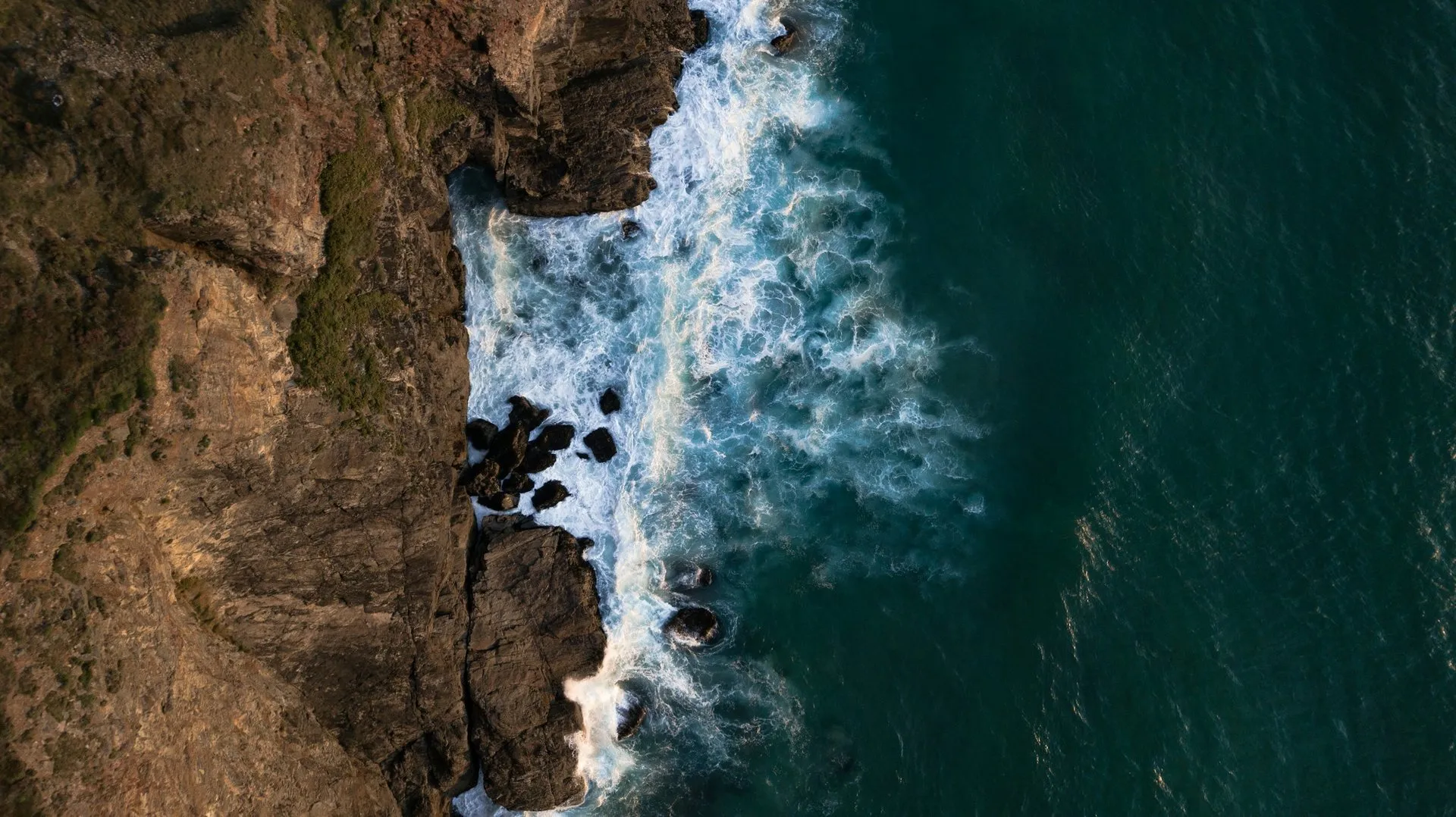 Aerial view of Atlantic waves breaking against the cliffs at Chapel Porth, Cornwall